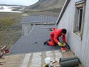 Arne K. jobber med papplegging p tilbygg nr. 1 sett mot C-delen